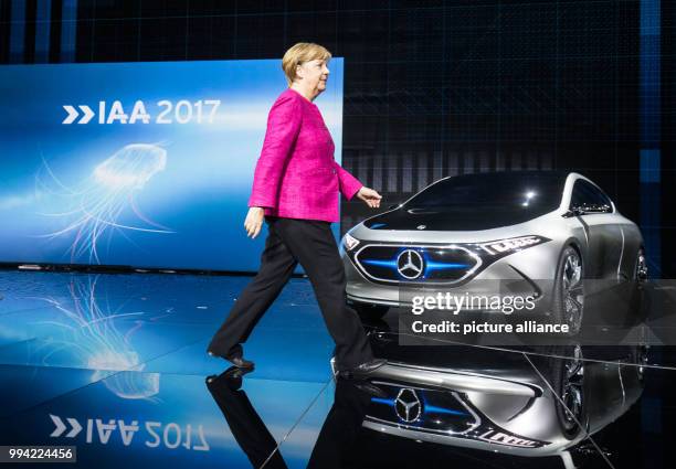 German chancellor Angela Merkel walks past a Mercedes EQ Aconcept e-car at the opening of the International Automobile Exhibition in Frankfurt am...