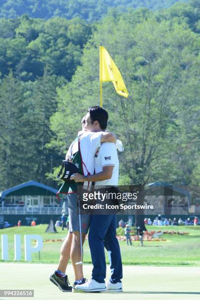 Kevin Na hugs his caddie on the 18th green during the final round of the Military Tribute at the Greenbrier in White Sulphur Springs, WV, on July 8,...