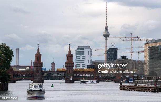 An underground train crosses the Oberbaum Bridge in Berlin, Germany, 14 September 2017, with the Rotes Rathaus town hall, the 'Living...