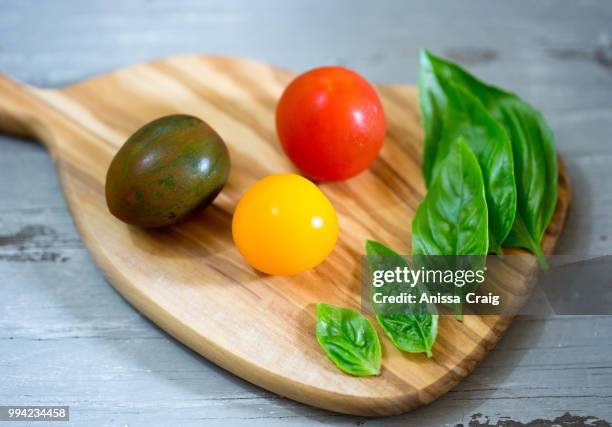 baby heirloom tomatoes with fresh basil - yellow tomato stock pictures, royalty-free photos & images