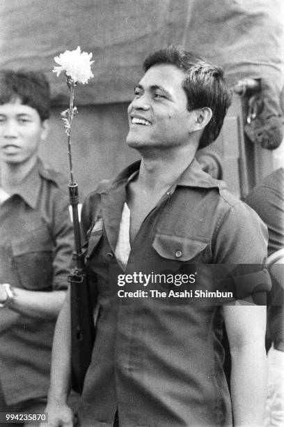 Philippine Constabulary soldier puts a flower at a muzzle of a rifle as National Defense Minister Juan Ponce Enrile and Chief of the Philippine...