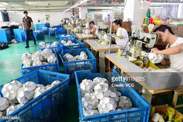 Workers make footballs overtime to process additional football orders from Russian, Brazilian and other overseas customers at the producing...
