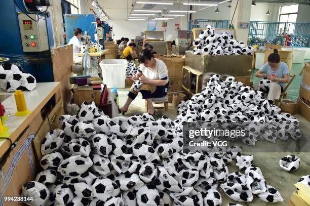 Workers make footballs overtime to process additional football orders from Russian, Brazilian and other overseas customers at the producing...