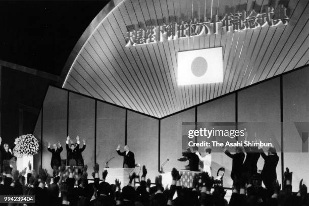 Emperor Hirohito waves while Crown Prince Akihito and participants make banzai cheers during the ceremony marking the 60th anniversary of the...