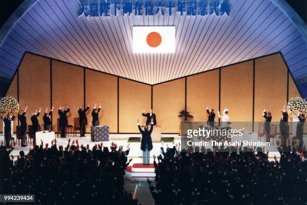 Emperor Hirohito waves while Crown Prince Akihito and participants make banzai cheers during the ceremony marking the 60th anniversary of the...