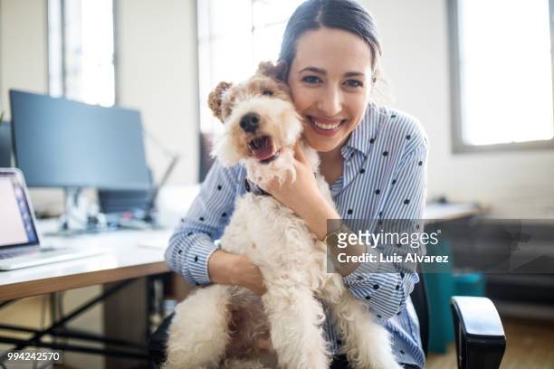 smiling female entrepreneur sitting with dog - department of interior holds a take your dog to work day stock pictures, royalty-free photos & images