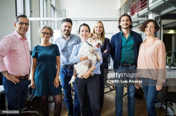 smiling business entrepreneurs standing with dog - soltanto un animale foto e immagini stock