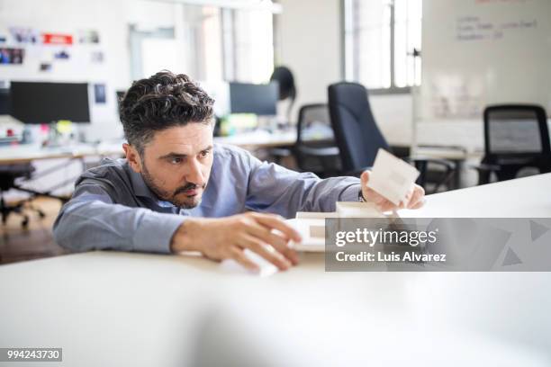 businessman examining architectural model on desk - architecture model stock pictures, royalty-free photos & images