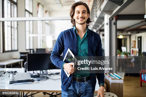 Smiling businessman standing with digital tablet Smiling businessman standing with digital tablet