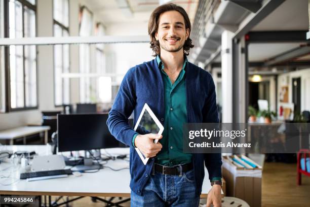 smiling businessman standing with digital tablet - business man portrait smiling stock-fotos und bilder