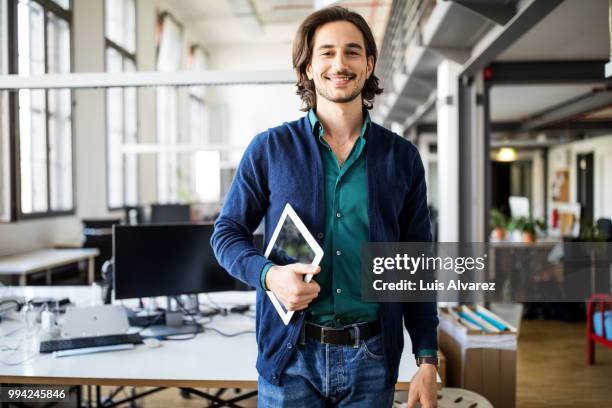 smiling businessman standing with digital tablet - coat imagens e fotografias de stock