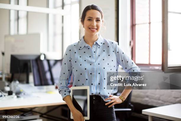 smiling businesswoman standing with digital tablet - technophiler mensch stock-fotos und bilder
