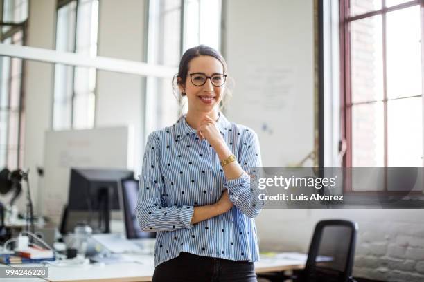 businesswoman wearing eyeglasses at office - one mid adult woman only fotografías e imágenes de stock