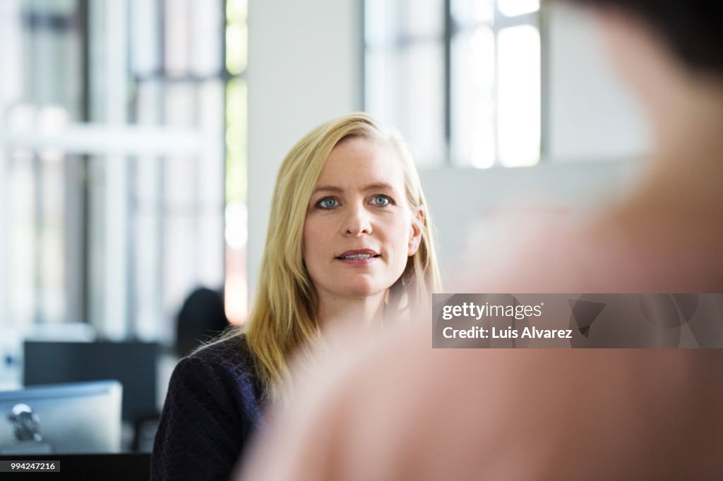 Blond businesswoman looking at female colleague
