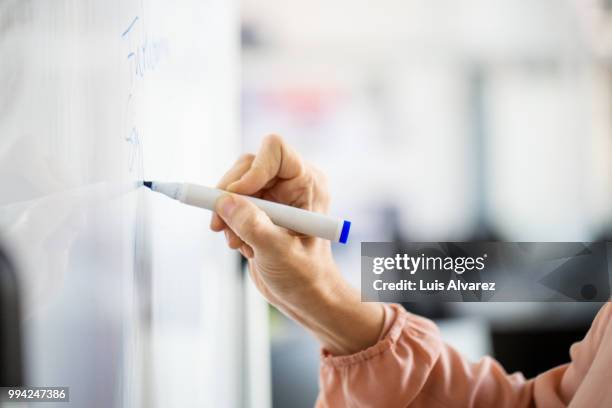 businesswoman writing on whiteboard during meeting - whiteboard bildbanksfoton och bilder
