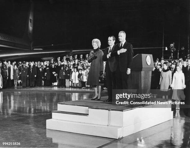 President Richard Nixon stands to attention for the National Anthem upon his arrival back at Andrews Field in the United States, after his trip to...