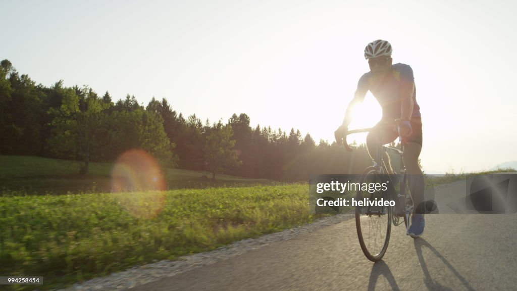 COPY SPACE: Professional male road biker enjoying a sunny cruise on his bicycle.