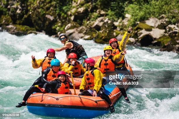 pequeño grupo de hombres y mujeres aguas blancas rafting en el río - rafting fotografías e imágenes de stock