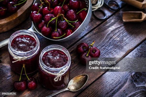 preparing homemade cherry jam on rustic kitchen table - colander stock pictures, royalty-free photos & images