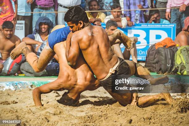 young wrestlers fight kushti at shoolini fair in solan, himachal pradesh. - mud wrestling stock pictures, royalty-free photos & images