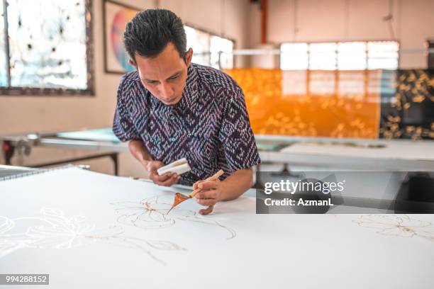 man painting in a batik workshop - batik painting stock pictures, royalty-free photos & images