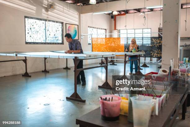 coworkers painting in a batik workshop - veil stock pictures, royalty-free photos & images