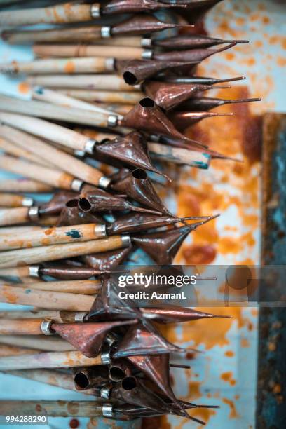 canting hand tool in batik workshop - malaysia batik stock pictures, royalty-free photos & images