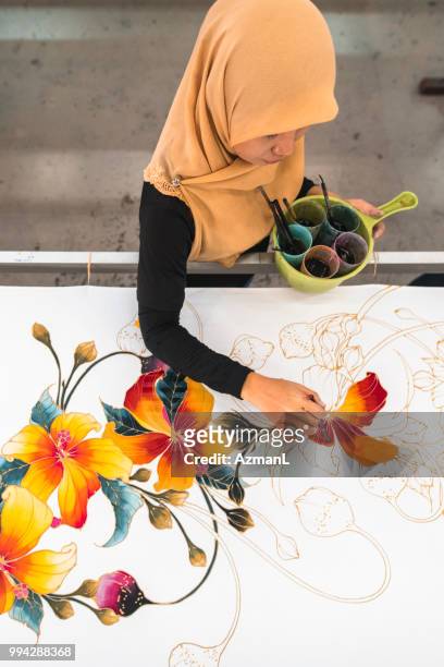 woman painting in a batik workshop - malaysia batik stock pictures, royalty-free photos & images