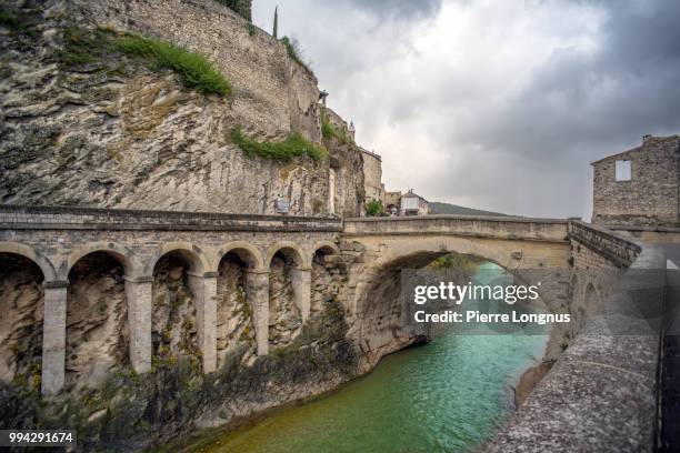roman bridge over the river ouvèze in the southern french town of vaison-la-romaine in provence - romaine stockfoto's en -beelden