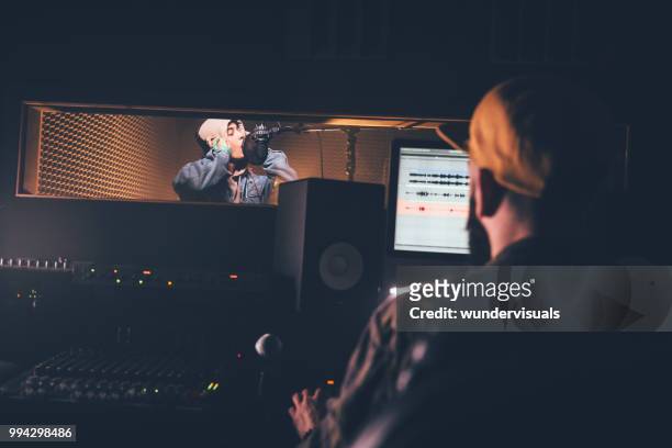hipster singer and music producer recording music in professional studio - music producer stock pictures, royalty-free photos & images