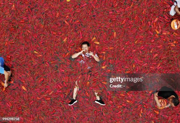 This photo taken on July 8, 2018 shows a contestant taking part in a chilli pepper eating competition in Ningxiang in China's central Hunan province....