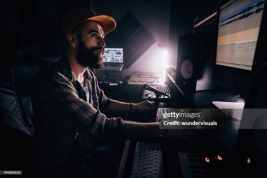 DJ werken in de muziekstudio en computerscherm te kijken