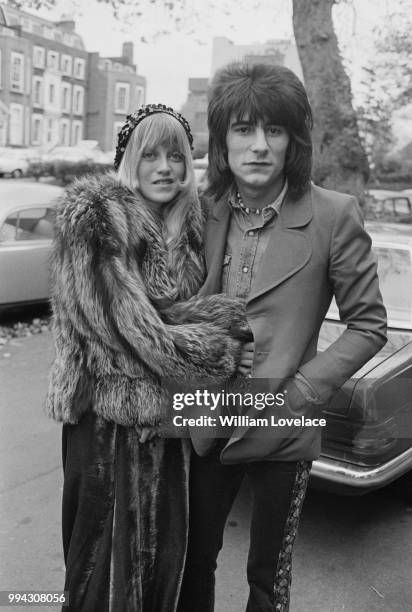 English musician and guitarist with Faces, Ronnie Wood pictured with his wife Krissy on a street in London on 10th November 1973.