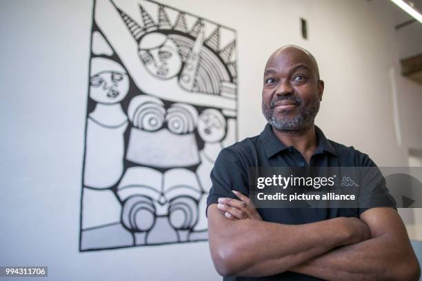 The Mozambican painter Dito Tembe standing in front of his painting in Schwerin, Germany, 15 September 2017. "Madgermanes" refers to contract workers...