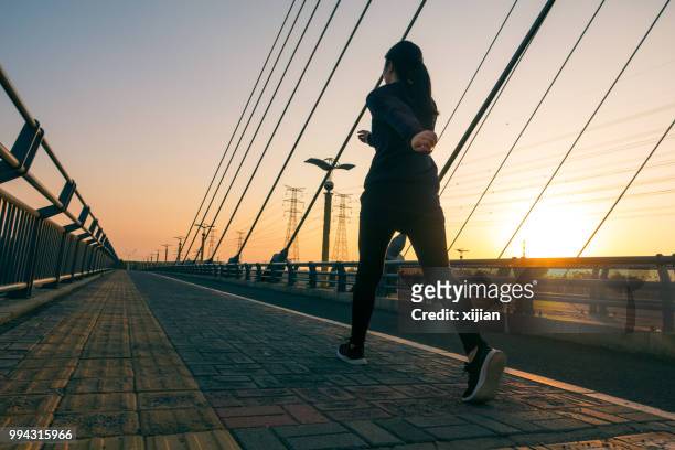 woman walking outdoors with sunlight - runner sunrise stock pictures, royalty-free photos & images