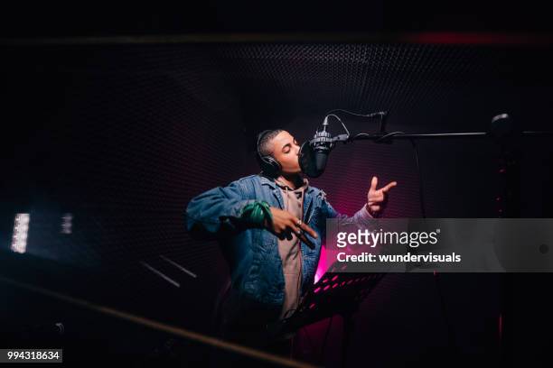 rapero afroamericano joven inconformista grabando canciones en estudio de grabación de música - músico pop fotografías e imágenes de stock
