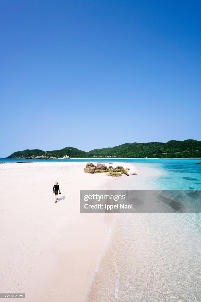 High angle view of man walking on deserted tropical island beach, Okinawa