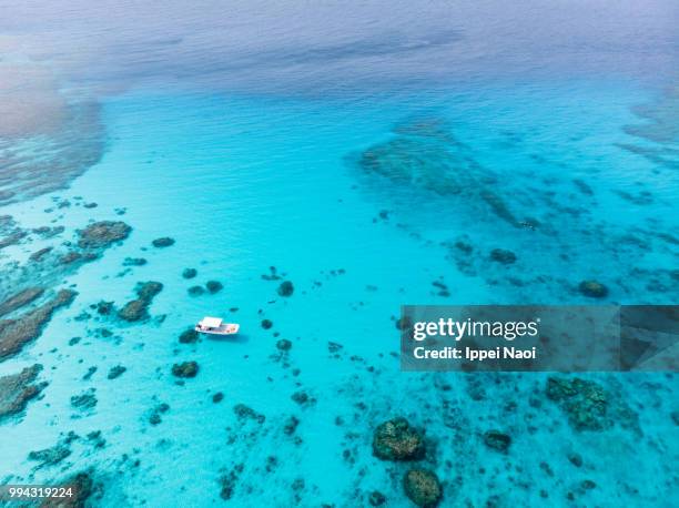 kerama islands national park with clear tropical water and boat from above, okinawa, japan - okinawa aerial stock pictures, royalty-free photos & images