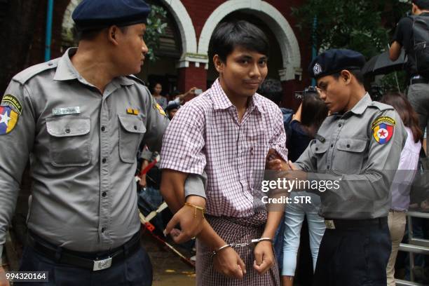 Detained Myanmar journalist Kyaw Soe Oo is escorted by police to a court for his ongoing pre-trial hearing in Yangon on July 9, 2018. - Two Reuters...