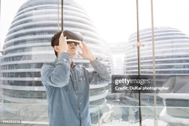 chinese man using the virtual reality headset - top prospects game ストックフォトと画像