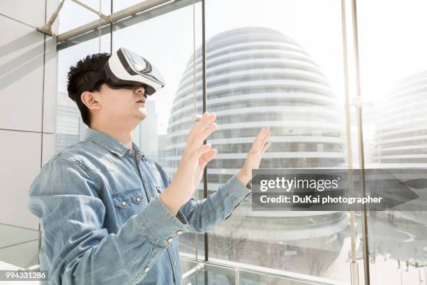 chinese man using the virtual reality headset - dukai stock pictures, royalty-free photos & images
