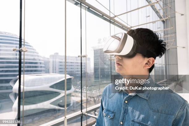 chinese man using the virtual reality headset - top prospects game ストックフォトと画像