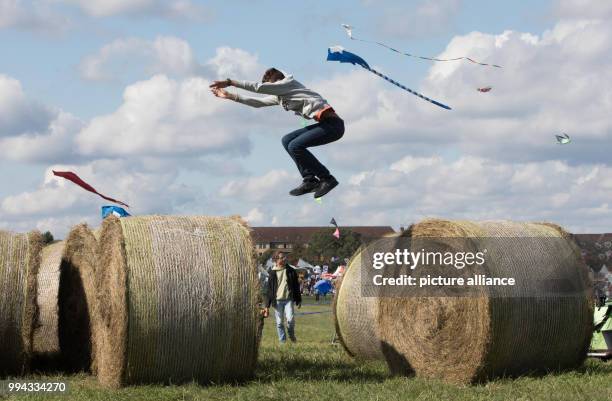 Gianni jumps from one bale of straw to another during the 'Festival der Riesendrachen' at the Tempelhofer Feld in Berlin, Germany, 16 September 2017....