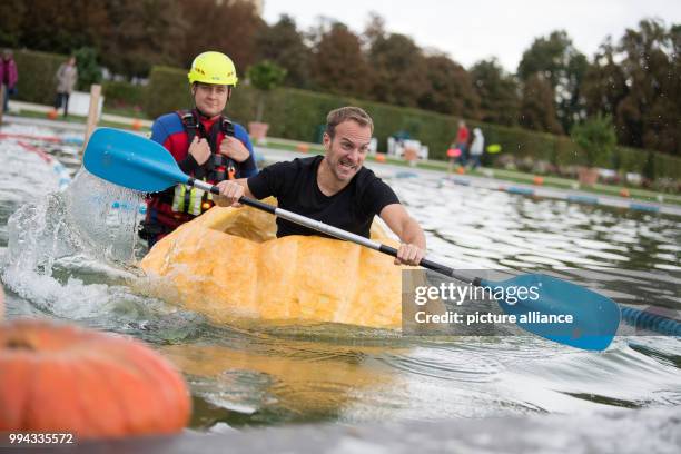 Steffen Ramin paddles in a pumpkin boat during the first day of the pumpkin boat race in the gardens of the Bluehende Barock in Ludwigsburg, Germany,...