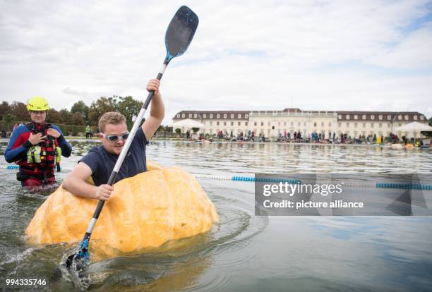 Ben Hearden paddles in a pumpkin boat during the first day of the pumpkin boat race in the gardens of the Bluehende Barock in Ludwigsburg, Germany,...