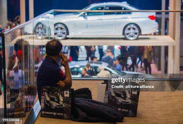 Man sits on the ground with advertising material in the fair hall of the automobile manufacturer BMW in Frankfurt am Main, Germany, 16 September...