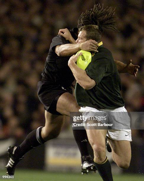 Dean Hall of South Africa is tackled by Tana Umaga of the All Blacks during the Tri Nations match between New Zealand and South Africa played at Eden...