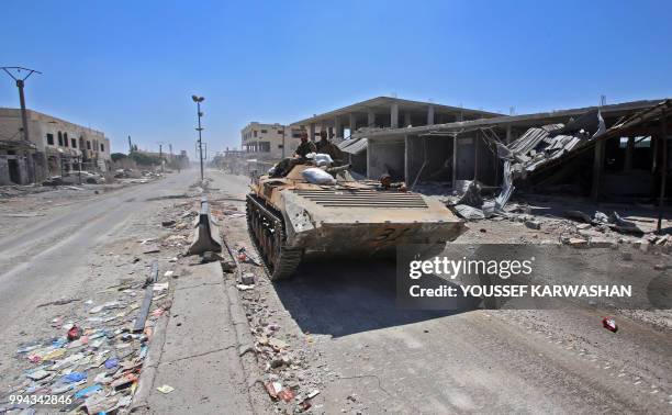 Syrian government soldiers ride in an infantry-fighting vehicle in the town of Saida in the west of Daraa province on July 7, 2018.