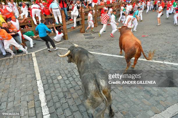 Participants run in front of Cebada Gago fighting bulls on the third day of the San Fermin bull run festival in Pamplona, northern Spain on July 9,...
