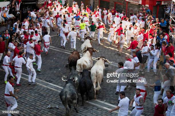 Participants run next to Cebada Gago fighting bulls on the third day of the San Fermin bull run festival in Pamplona, northern Spain on July 9, 2018....